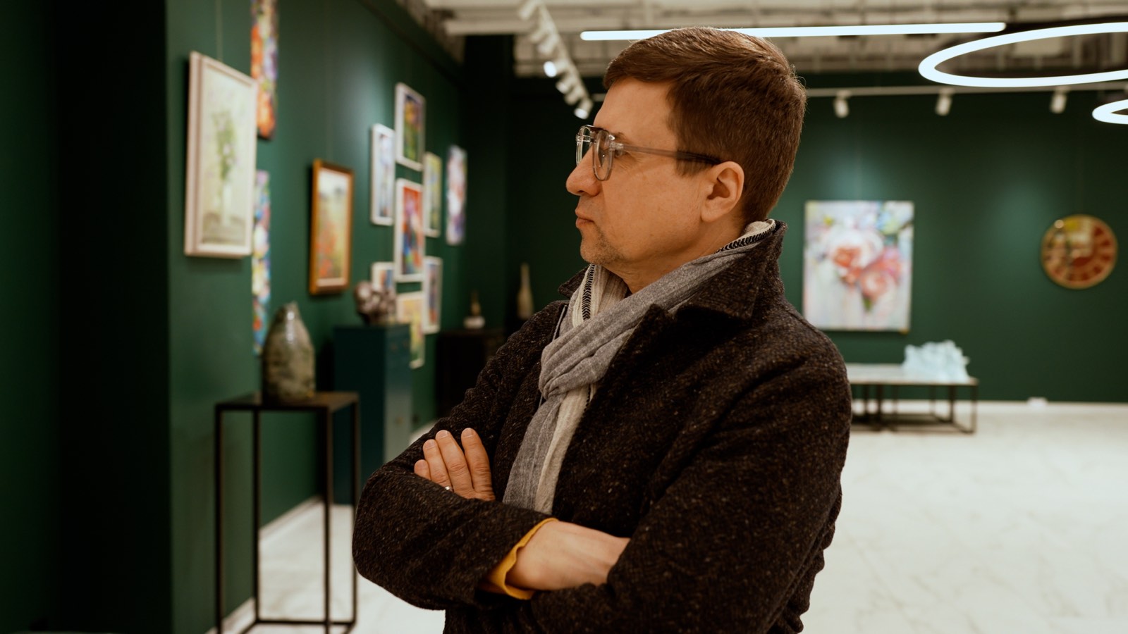 Una persona osserva opere d’arte in galleria.